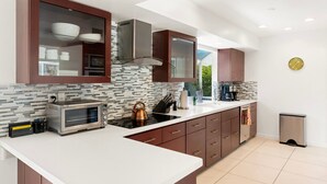 A modern kitchen with a microwave, kettle, and coffee maker.