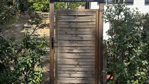 Una puerta de madera con un letrero que dice "Oceanside Villa" que da paso a un edificio con techo de tejas.