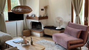 Una sala acogedora con chimenea, asientos cómodos y televisor.