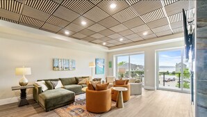 Amplia sala de estar con un diseño moderno de techo, un sofá grande, una mesa de centro y vistas al exterior.