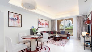 A spacious living room with a dining area, large windows, and modern decor.