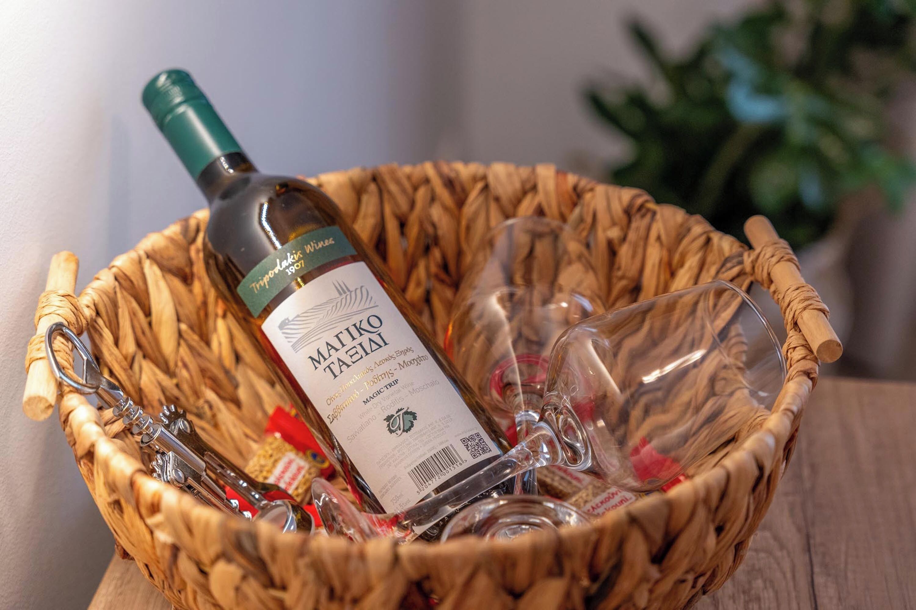Una cesta de mimbre con una botella de vino MaiKo Taelai, una copa de vino y un sacacorchos.