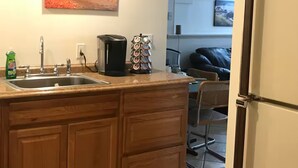 A kitchen with a sink, coffee maker, and a decorative item on the counter. - Beautiful Back Cove Area/ "Maine the Way Life Should Be" (Portland)