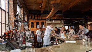 A bar area with a brick wall, wooden ceiling, and a bar counter. - Beautiful Back Cove Area/ "Maine the Way Life Should Be" (Portland)