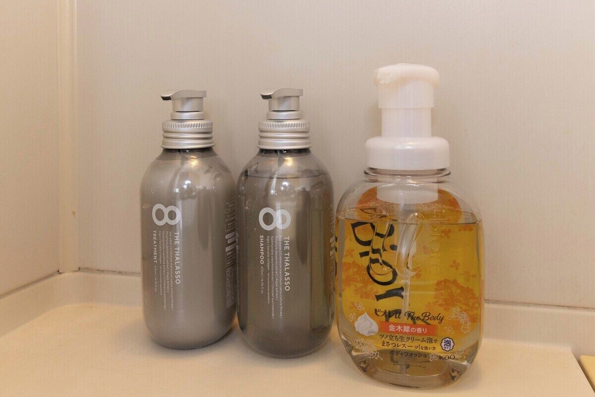 Three bottles of shampoo and conditioner on a bathroom counter.