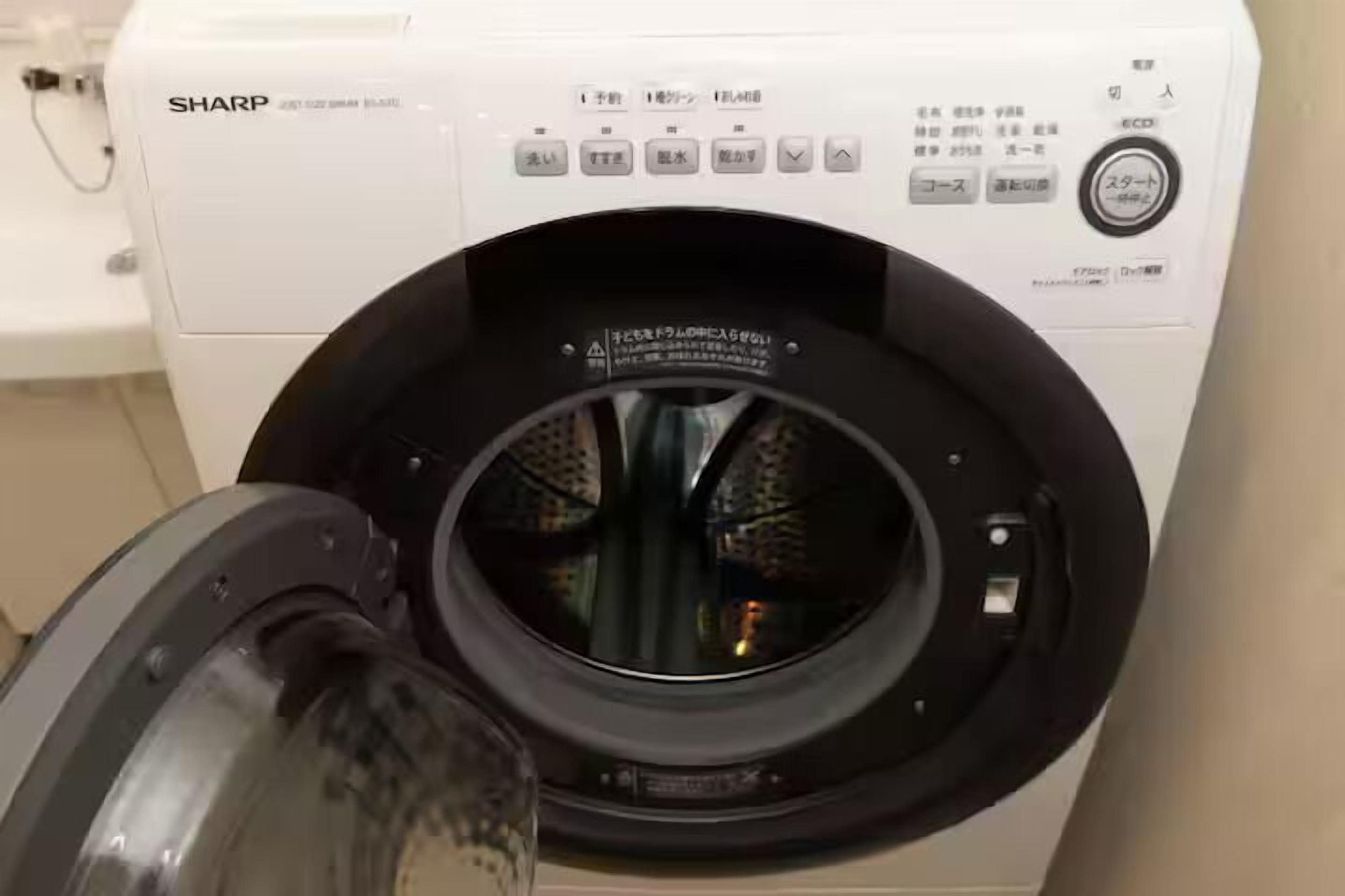 A front-loading washing machine with a control panel and a transparent door.