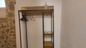 Ein Metallstockbett mit einer Holzablage und einer Kleiderstange.