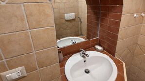 Ein Badezimmer mit Waschbecken, Spiegel und Duschbereich.