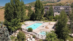 Zona residenziale con piscina circondata da sdraio e vista sulle montagne.