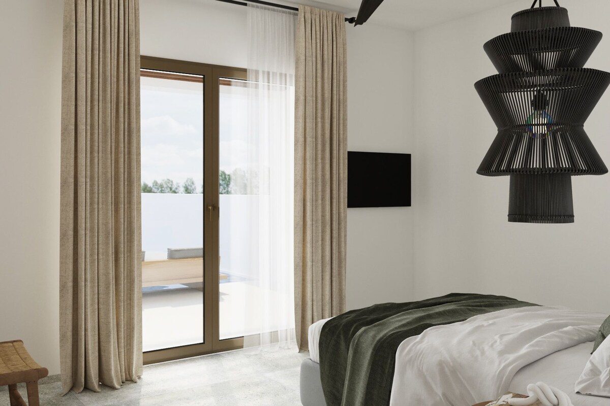 A bedroom with a bed, a window with curtains, a wall-mounted TV, and a hanging light fixture.