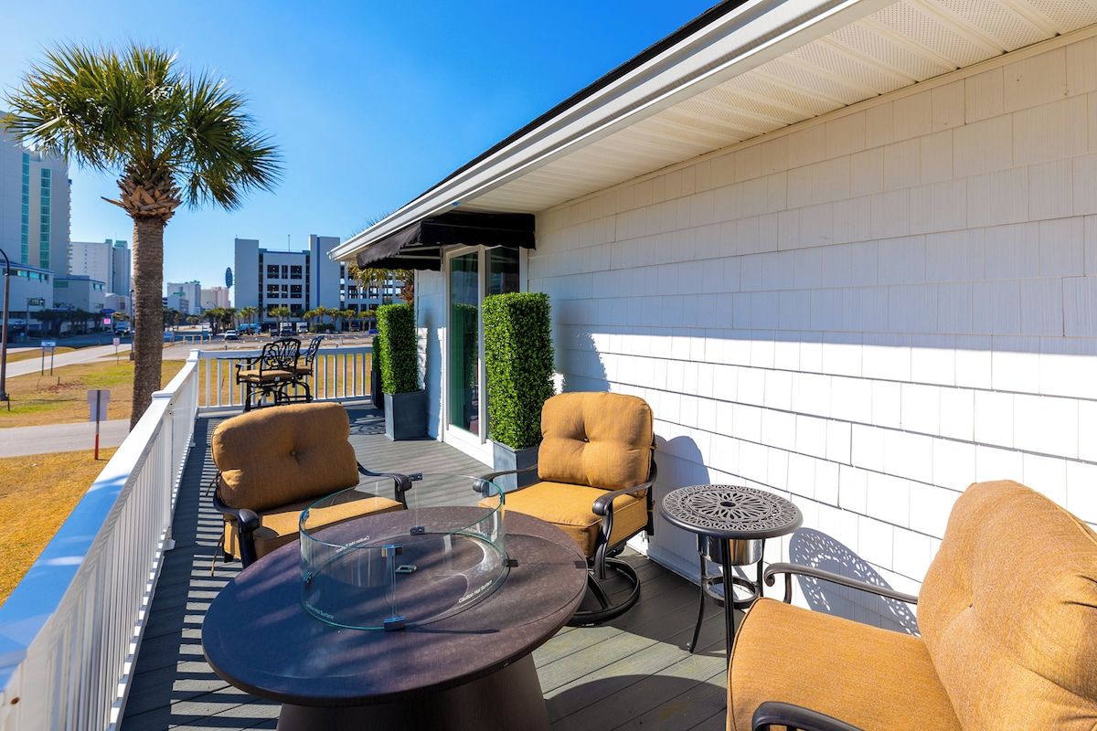 Une terrasse sur le toit avec des sièges extérieurs, un palmier et une vue sur la ville.