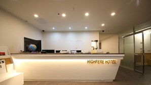 A hotel reception desk with a globe, a phone, and a sign instructing guests to put their key in the key holder. - HOTEL HIGHFERE (Changwon)