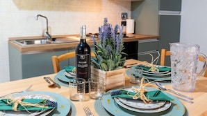 A dining table set with plates, glasses, and cutlery, a bottle of wine, and a decorative plant. - Cosy apartment for 4 people with WIFI, balcony, pets allowed and panoramic view (Andora)