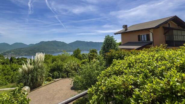 A house with a view of mountains and a lake.