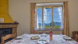 A dining area with a table set for four, a fireplace, and a window with a mountain view.