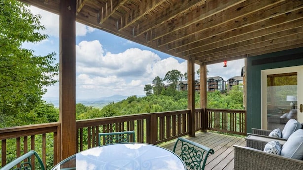 A covered outdoor area with a wooden deck, a round table, and wicker furniture. - Peaceful 2/2 with VIEWS: Echota (Banner Elk)