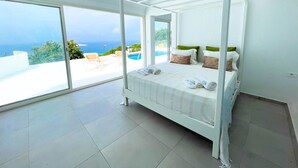 A four-poster bed with a view of the sea and a pool. - Padel Resort Villa Romana 2bdrs (Raf Raf)