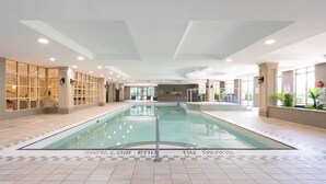 An indoor swimming pool with clear water, tiled floor, and a 'Shallow End' marking. - Premium 2BR Extended Stay Near YYZ Free Parking Included (Toronto)