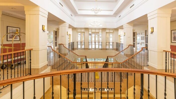 A grand hotel lobby with a central staircase, high ceilings, and large windows. - Premium 2BR Extended Stay Near YYZ Free Parking Included (Toronto)