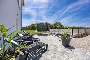 A patio with outdoor furniture, a trampoline, and a garden area. - Lara Holiday Home (Kanfanar)