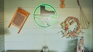 A rustic interior with a Texas state emblem, a wooden tool rack, and a decorative wreath. - Private Hot Tub - 1.4 miles to Main Street - 5 minute drive. (Fredericksburg)