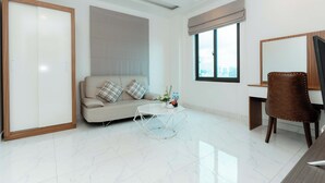A modern living room with a sofa, a coffee table, a desk, and a chair.