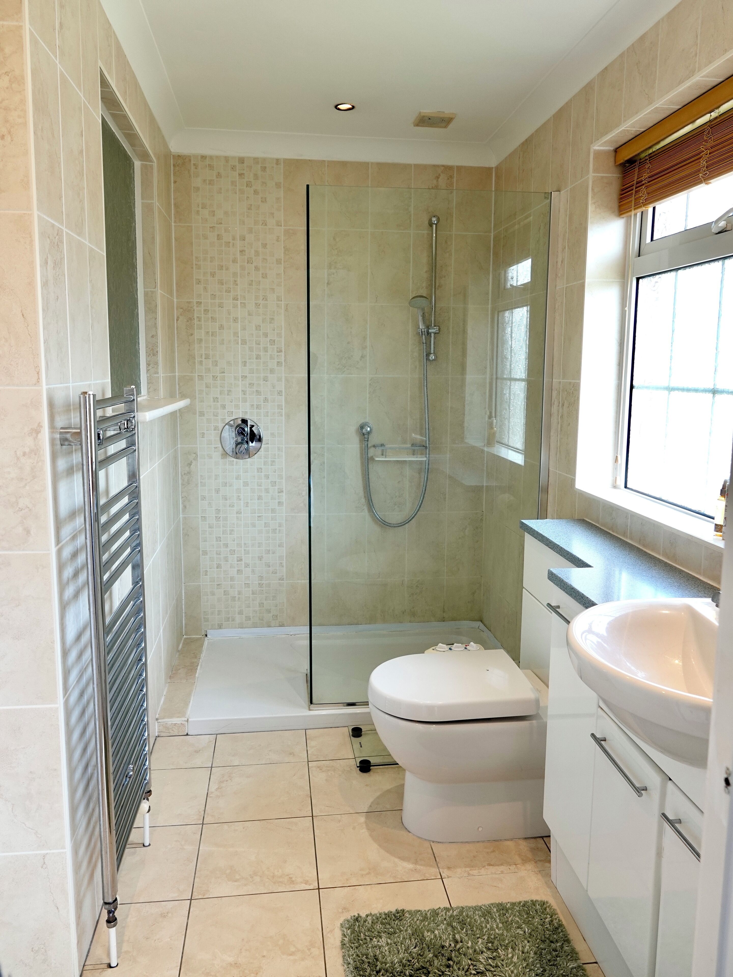 Une salle de bain avec une douche à parois de verre, des toilettes et un lavabo.