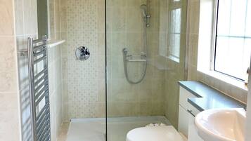 Une salle de bain avec une douche à parois de verre, des toilettes et un lavabo.