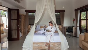 A room with a bed under a canopy, a desk, a chair, and a sofa. - Green Kulu Villa (Tampaksiring)
