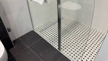 Een douche, een haardroger, handdoeken, toiletpapier