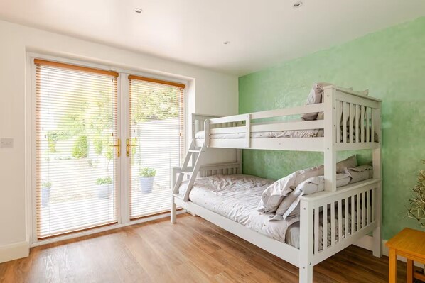 A bunk bed room with a sliding glass door leading to a balcony.