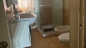 A bathroom with a shower, toilet, and sink.
