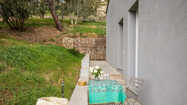 A patio with a table set for two, a stone wall, and a grassy area with trees. - Elfranch - El.Chi.Ma. by Wonderful Italy (Polizzi Generosa)