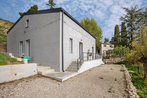 Il s’agit d’un bâtiment moderne, sur lequel on peut lire l’inscription « ELCHIMA » sur une plaque. Son architecture est simple et épurée, avec une allée en gravier et un mur de pierre qui entoure la propriété.
