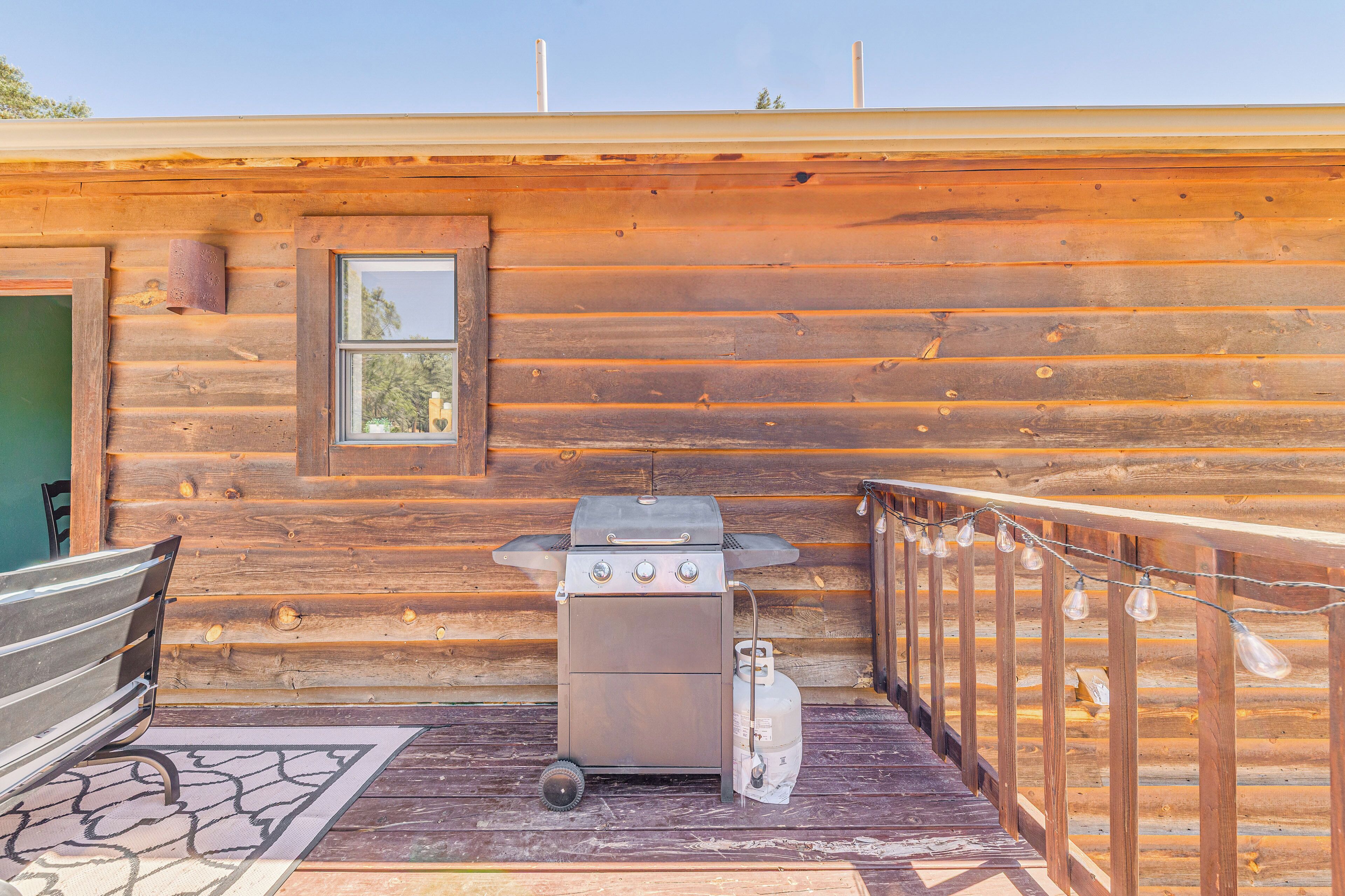 Een houten hut met een metalen grill en een raam.