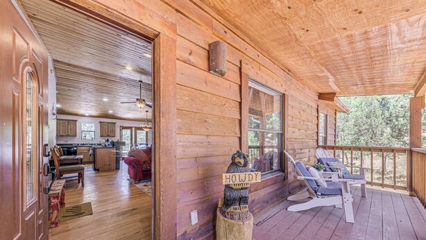 L’intérieur d’une cabane en bois comprend une véranda, un coin repas et une cuisine.