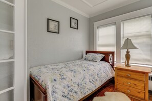 A bedroom with a bed, wooden dresser, and two framed pictures on the wall. - 5 Mi to Beaches: Historic Apartment in Westerly! (Westerly)