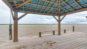 Une terrasse en bois surmontée d’une structure de toit en métal.