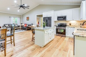 A spacious kitchen with white cabinets, a large island, and modern appliances.
