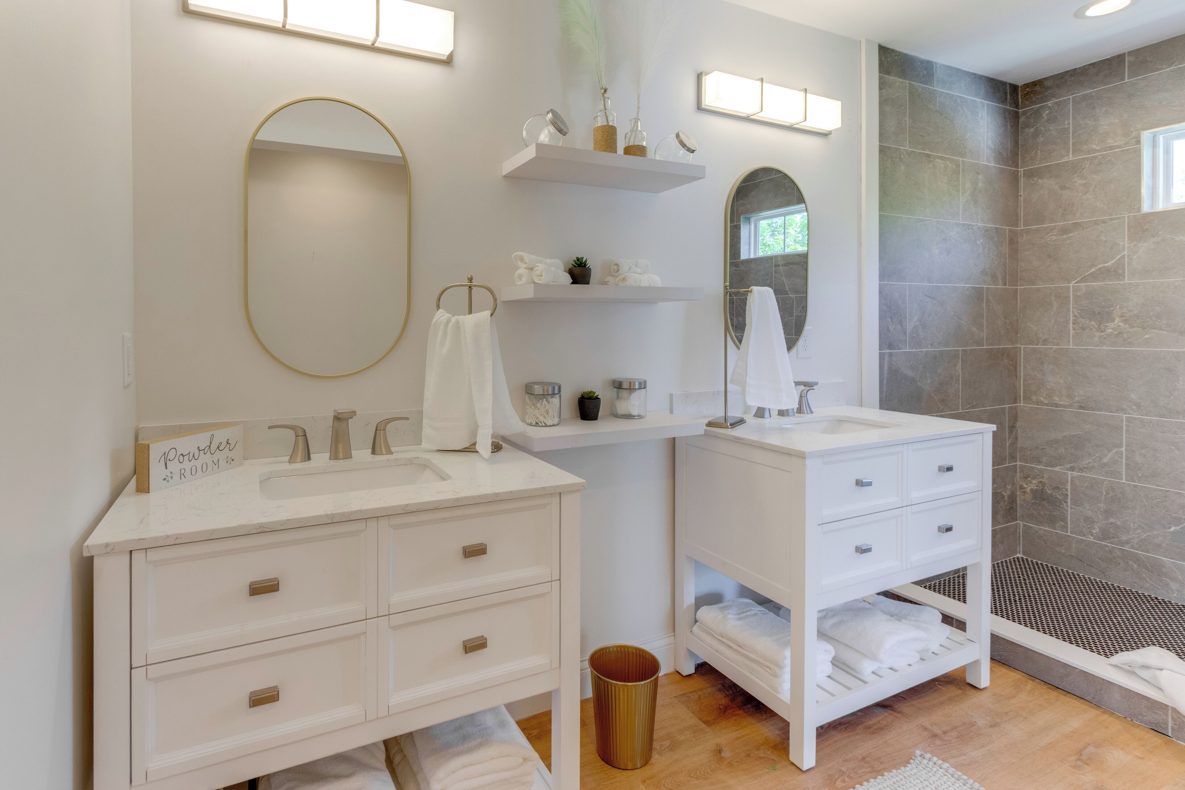 Een moderne badkamer met twee wastafels, een grote spiegel en een douchehoek.