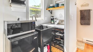 A compact kitchen with a built-in oven, a sink, and a window providing natural light. - Hike, Fish & More: Cozy Studio w/ Yard in Augusta! (Augusta)