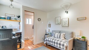 A cozy bedroom with a bed, bedside table, and a nightstand. A door leads to the bathroom. - Hike, Fish & More: Cozy Studio w/ Yard in Augusta! (Augusta)
