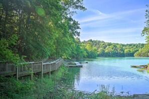 A wooden dock extending into a calm lake surrounded by dense forest. - Smokies Cabin on Douglas Lake w/ Resort Pool (Sevierville)