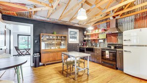 A kitchen with wooden floors, a dining table, chairs, a refrigerator, and various kitchen appliances. - 1 Mi to Town: Woodland Park Home w/ Yard! (Woodland Park)