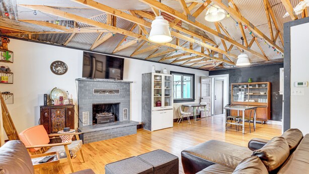 A spacious living area with a fireplace, wooden beams, and a dining area with a table and chairs. - 1 Mi to Town: Woodland Park Home w/ Yard! (Woodland Park)