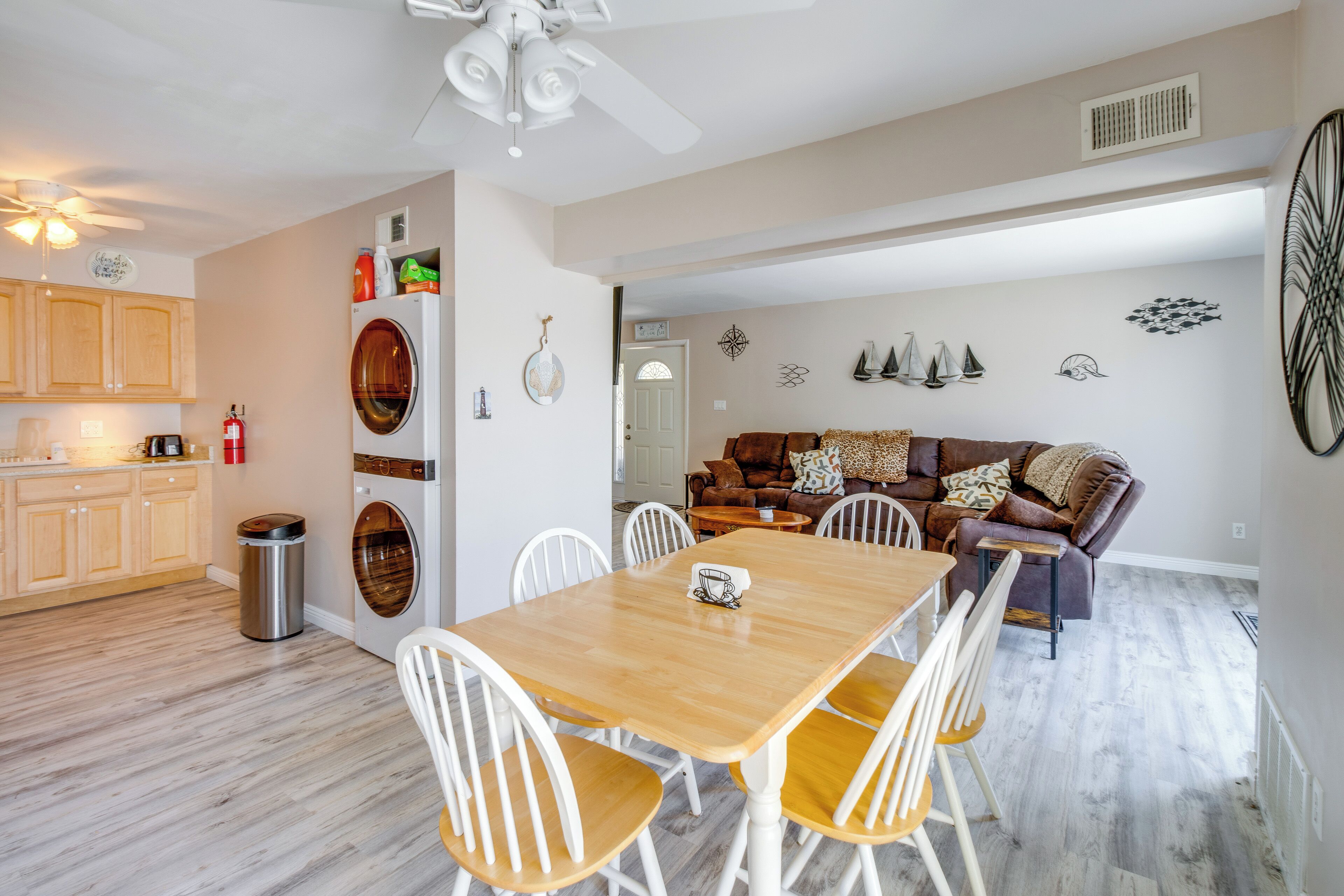 A modern kitchen with wooden cabinets, a built-in oven, and a ceiling fan.