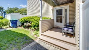 A house with a covered porch, a front door, and a small seating area. - Walk to Brigantine Beach: Condo w/ Furnished Patio (Brigantine)
