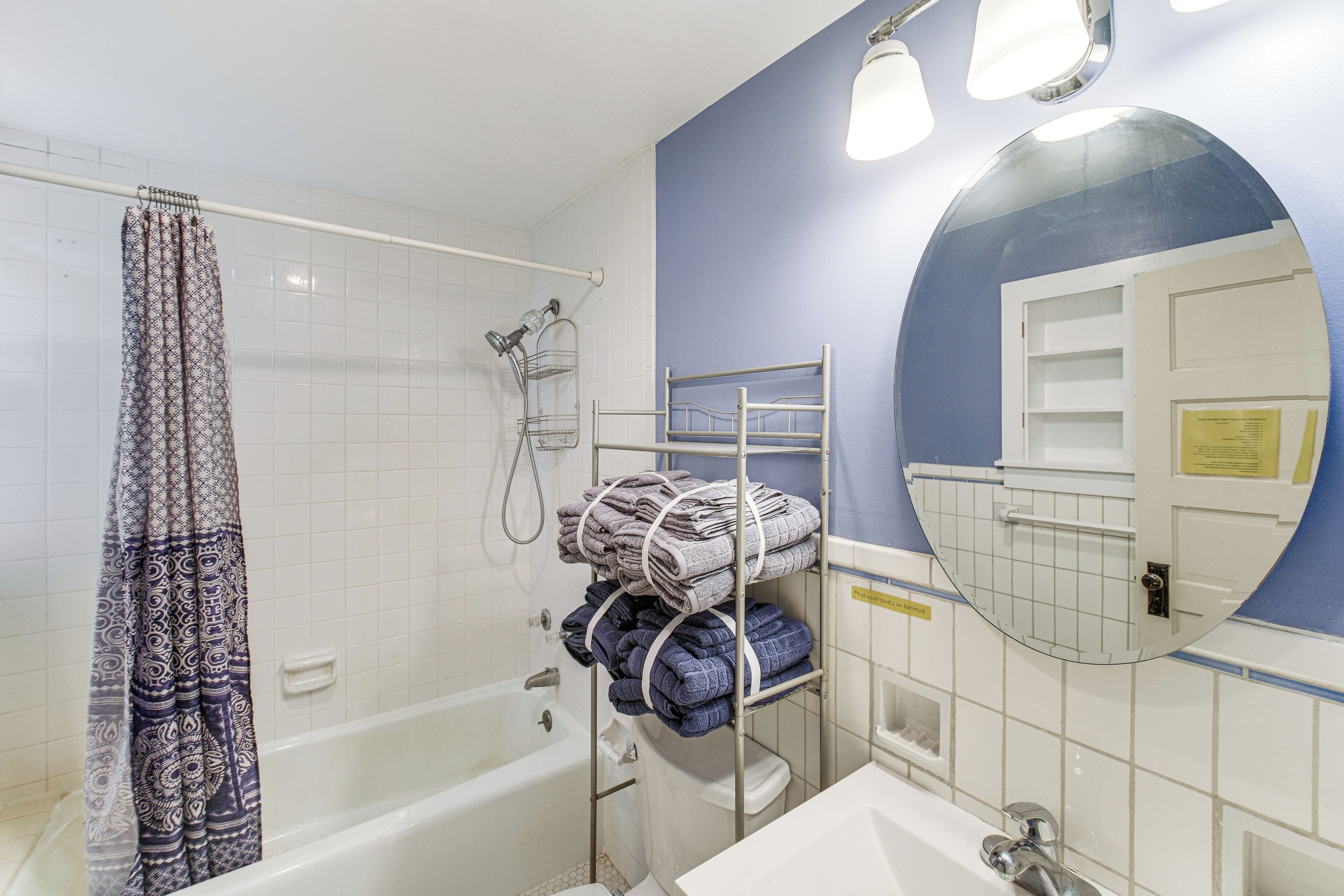 A bathroom with a bathtub, a shower, a sink, and a mirror.