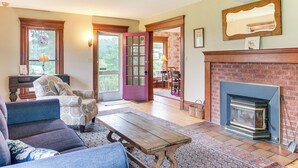 A living room with a fireplace, a sofa, a coffee table, and a patterned rug. - 2 Mi to Chardon Square: Family Farmhouse Escape (Chardon)
