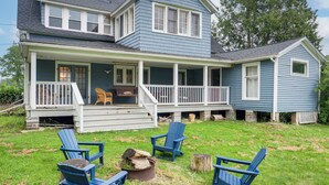 A two-story house with a porch, blue exterior, and a fire pit area with chairs. - 2 Mi to Chardon Square: Family Farmhouse Escape (Chardon)